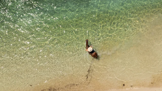Shot aérien d'une femme à dos de cheval, dans la mer